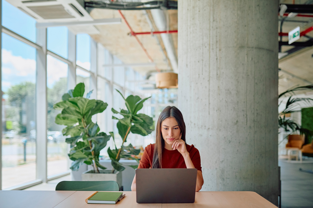 IT professional working at laptop in modern office